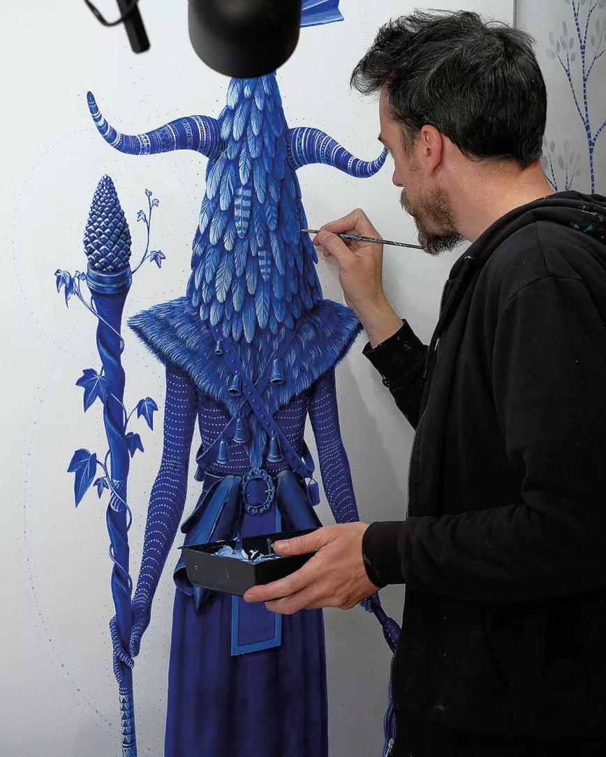Juako en su estudio pintando Mascarada I, la que abre las puertas, acrílico sobre lienzo, 200x100 cm, 2019