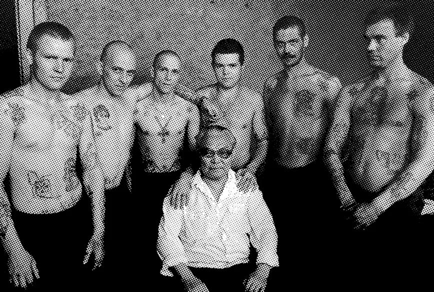 Danzig Baldaev, funcionario de prisiones ruso que dibujó y documentó el significado de unos tres mil seiscientos tatuajes, rodeado de presos.