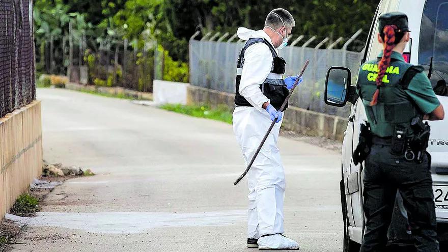 La Guardia Civil examina una barra de hierro que apareció en el lugar del homicidio.