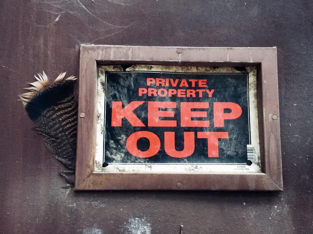 Cartel de bienvenida a la cabaña: Keep out (“No entrar”).
