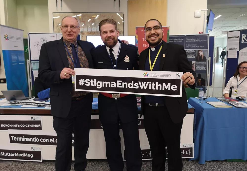 En la CND (reunión anual de la Comisión de Estupefacientes) de 2020, mostrando la campaña #StigmaEndsWithMe de la organización canadiense CAPSA (Community Addictions Peer Support Association) junto a Gord Garner, su director ejecutivo, y un policía de Canadá.