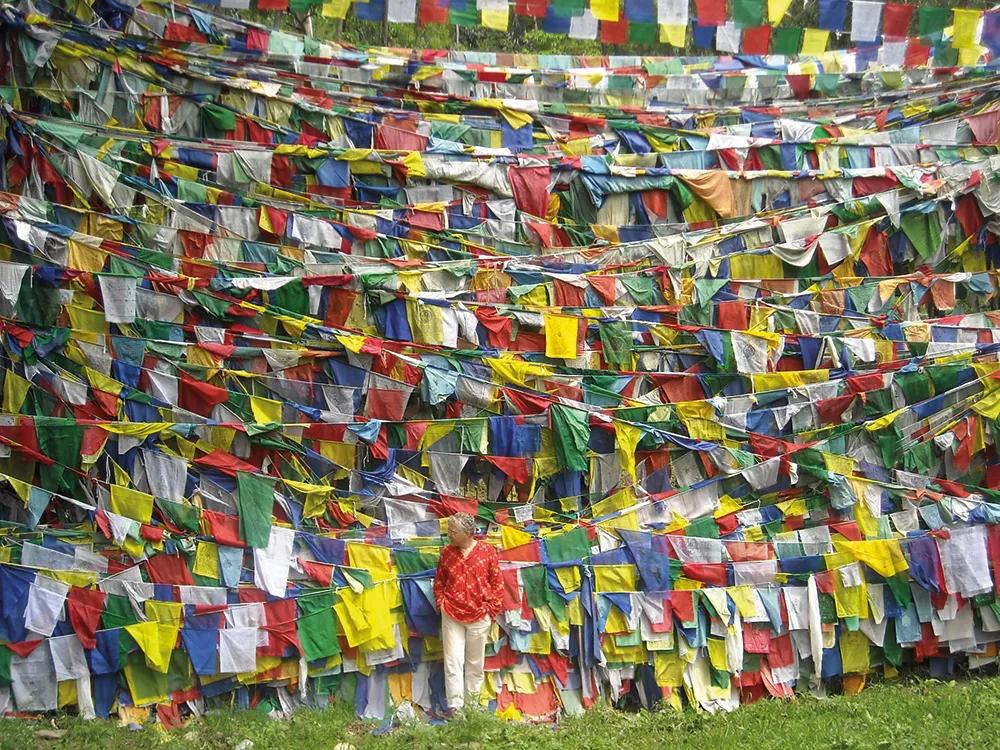 Antonio Orihuela con un fondo de banderas de plegarias budistas en Rewalsar, lugar de peregrinación en Himachal Pradesh, India