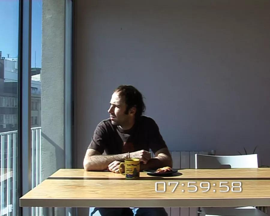 Captura de la video instalación Sobre perder el tiempo (2007) de Raquel Friera. Se contrata a un actor para que  “pierda el tiempo” durante ocho horas –el mismo intervalo de una jornada laboral en España–, lo que se entiende por  “perder el tiempo” según los resultados obtenidos en una investigación realizada previamente entre los ciudadanos de Barcelona.