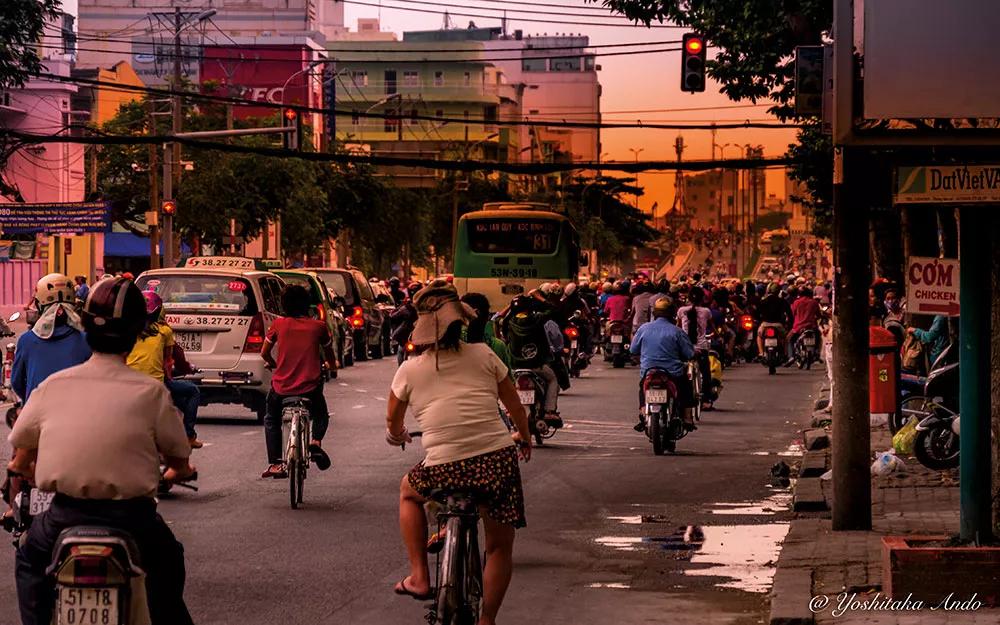 Típica calle de Ho Chi Minh al atardecer, con su espectáculo de coches, autobuses, motos y bicis en caótico orden.