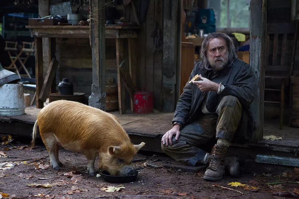 Cage caracterizado como afligido ermitaño, alimentando a su talentoso cerdo trufero en los bosques de Seattle (Pig, 2022).